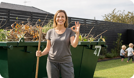 Skip Bin Hire Launceston homeowner filling a skip bin with garden waste in a backyard
