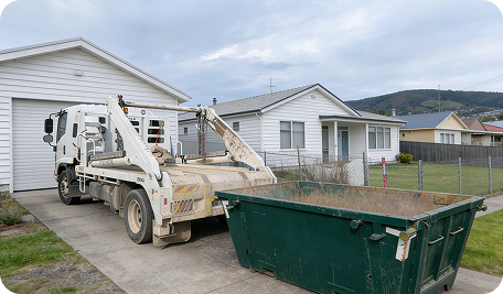 Skip bin hire delivery in Blackmans Bay with truck placing a skip bin in front of a residential property for household, garden, and renovation waste.